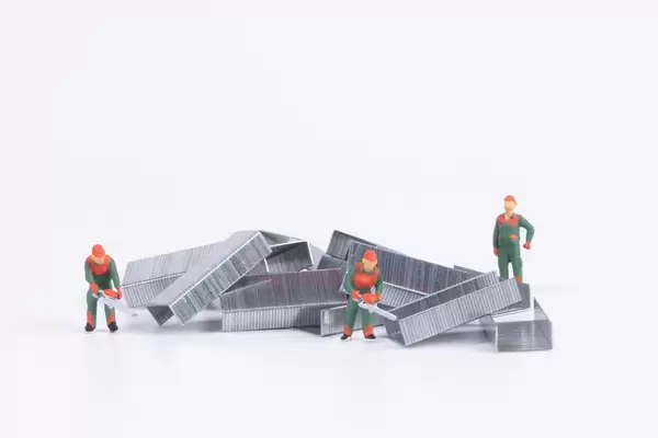 Group of workers and pile of metal steel staples