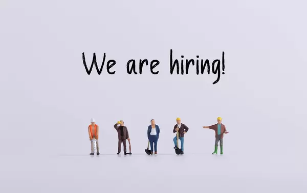 Group of workers with We are hiring text