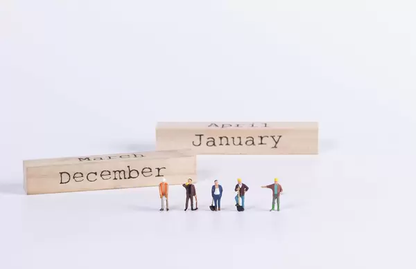 Group of workers with wooden block with December and January text