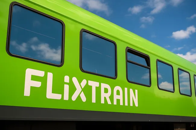 Grün lackierter Flixtrain-Zug vor Himmel