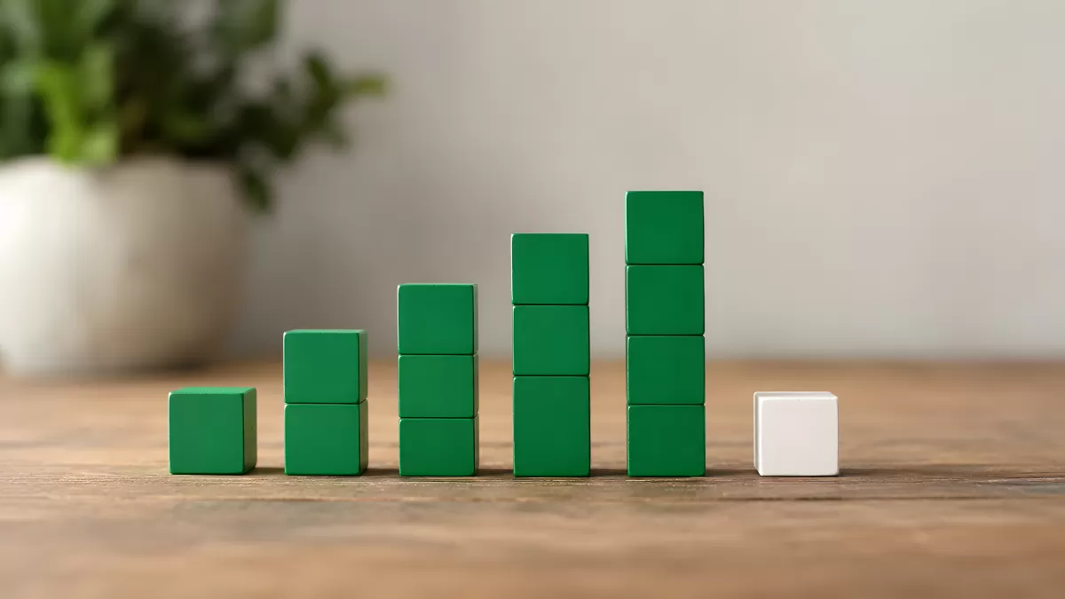 Grüne Holzwürfel als Balkendiagramm auf Holztisch