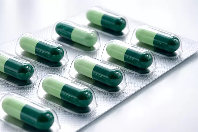 Grüne Medikamentenkapseln in Blister-Packung