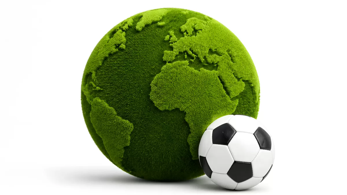 Grüner Globus mit Fußball vor weißem Hintergrund