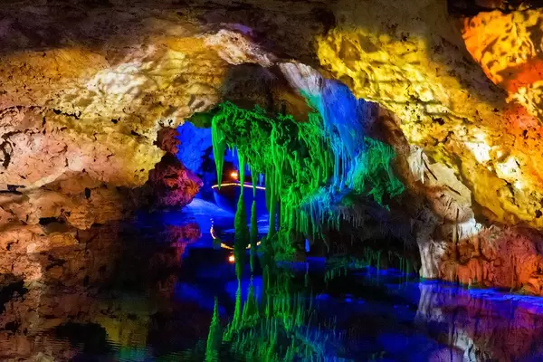 Grün beleuchtete Stalaktiten spiegeln sich im Wasser des Meeres von Venedig. Cuevas del Hams Höhlen