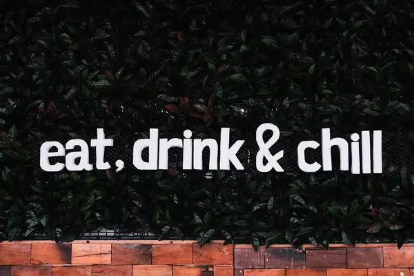 Grüne bepflanzte Wand mit den Worten "Eat, drink and chill"  - essen, trinken und entspann