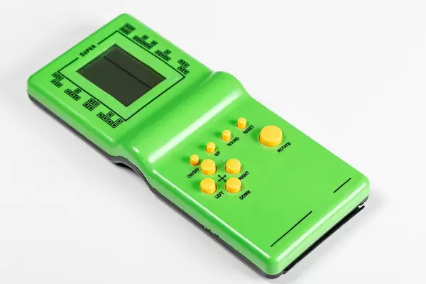 Grüne Handheld-Konsole: Elektronisches Tetrisspiel vor weißem Hintergrund