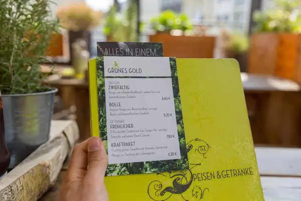 Grünes Gold - Speisekarte mit Rindfleischburger, veganem Burger und grünem Smoothie im Hans im Glück Restaurant