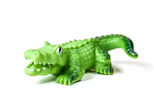 Grünes Krokodil-Spielzeug auf weißem Hintergrund