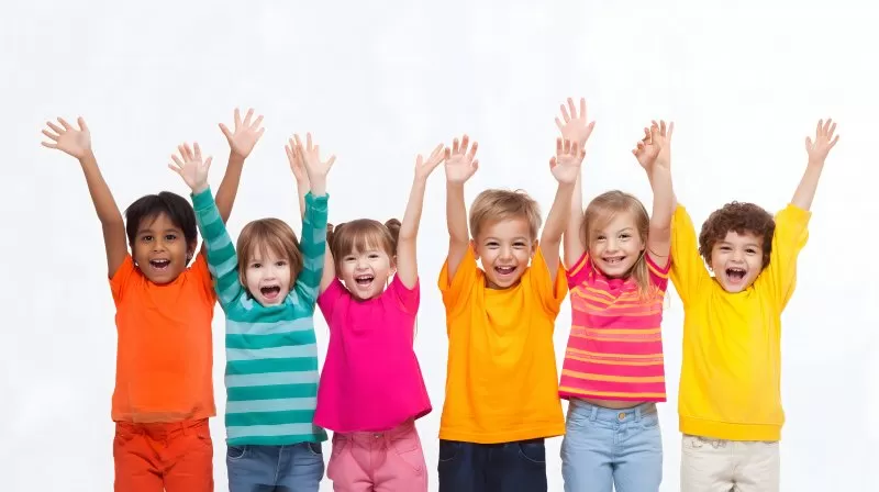 Gruppe lachender Kinder mit erhobenen Armen vor weißem Hintergrund