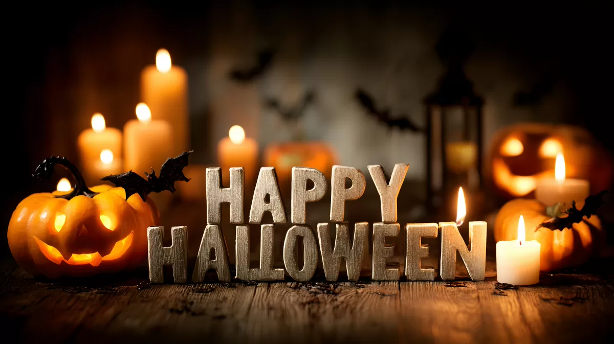 Gruseliges Halloween-Arrangement mit Kürbissen und Kerzen