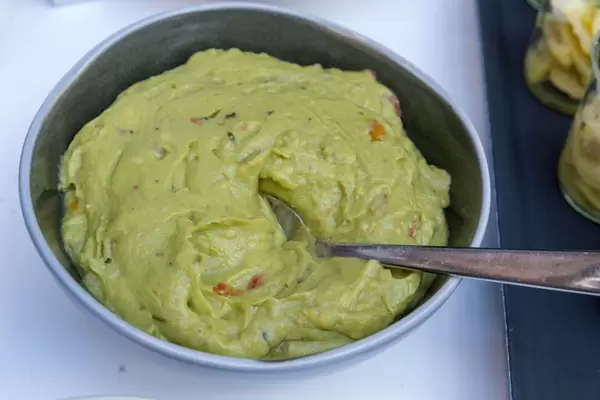 Guacamole - Avocado-Dip in einer Schüssel mit einem Löffel