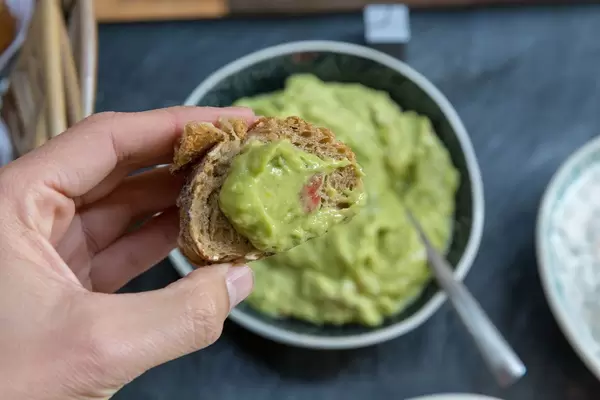 Guacamole mit Tomaten auf einer Scheibe Vollkornbrot
