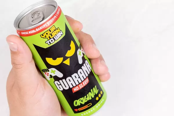 Guarana can in the hand above white background
