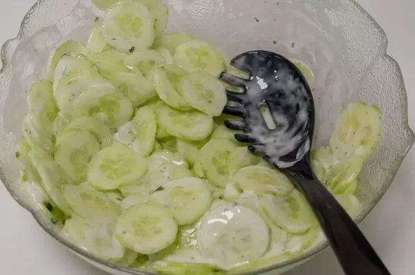 Gurkensalat mit weißem Dressing in einer Glasschüssel