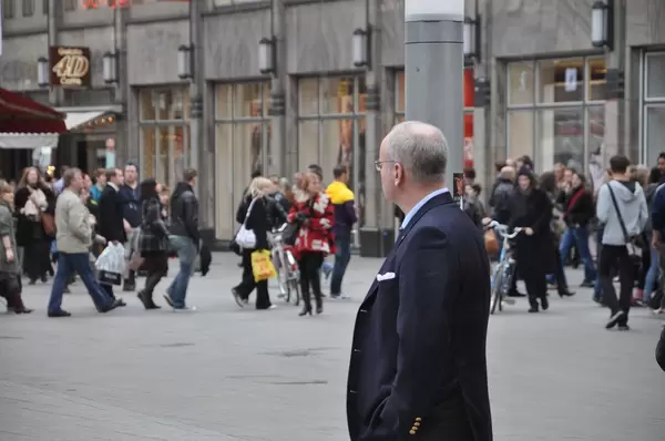 Gut gekleideter Mann beobachtet Passanten