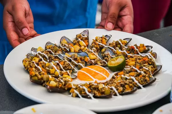 Guy serving a delicious greenshell mussel dish (Flip 2019)