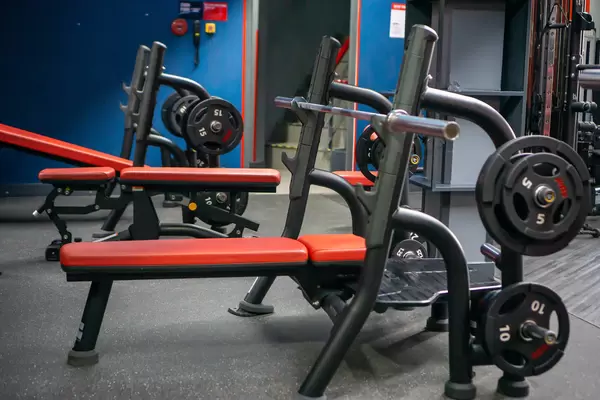 Gym Weight Bench with Barbell, Weight Rack and different Weights with Incline Bench and Adjustable Bench in the Background