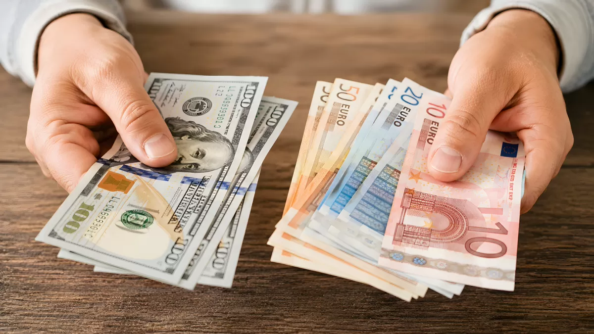Hände halten US-Dollar und Euro-Scheine im Vergleich