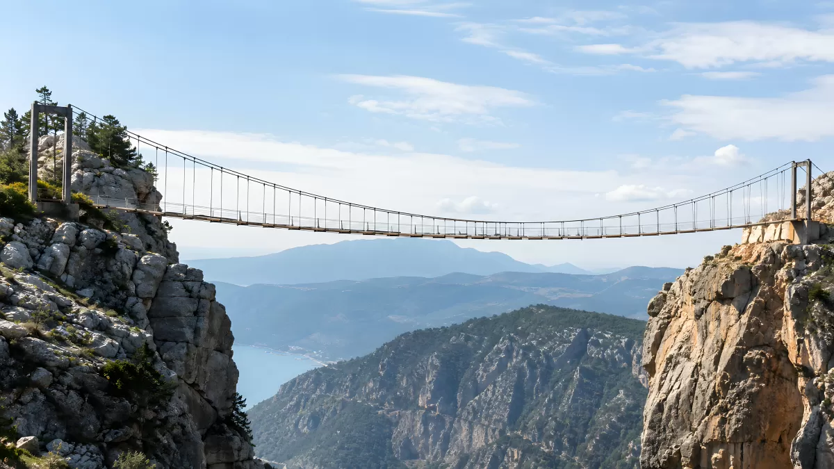 Hängebrücke zwischen Felsen über tiefem Bergtal