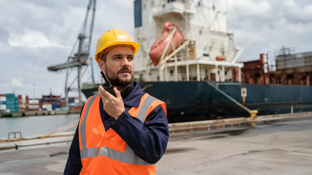 Hafenarbeiter mit Walkie-Talkie am Containerschiff