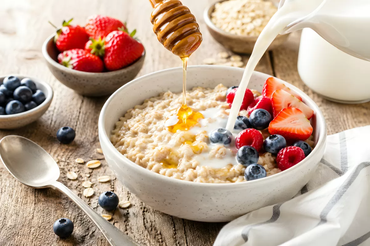 Haferbrei mit Beeren, Honig und Milch im Frühstück