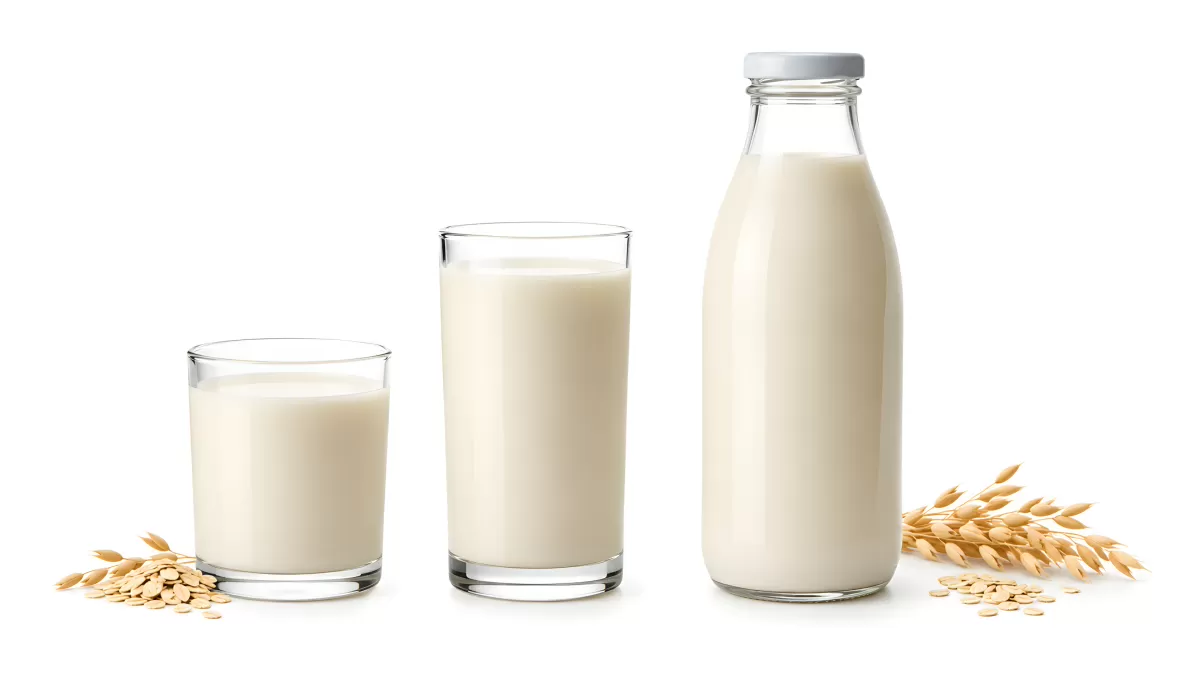 Hafermilch in zwei Gläsern und einer Glasflasche