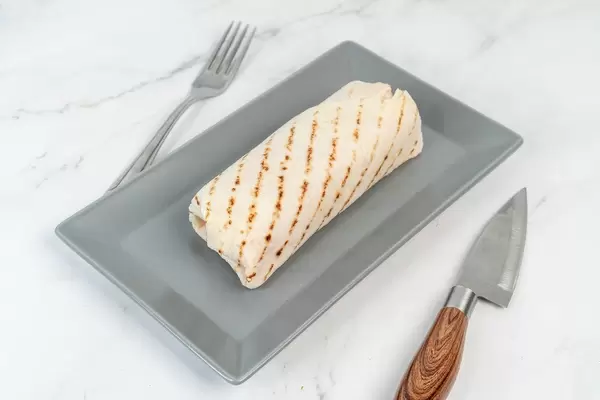 Hähnchenfleisch mit Gemüse in einer Tortilla eingerollt, serviert auf einem Teller