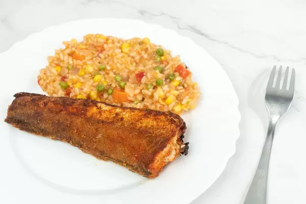 Hake served with Risotto and Vegetables on the white plate (Flip 2019)