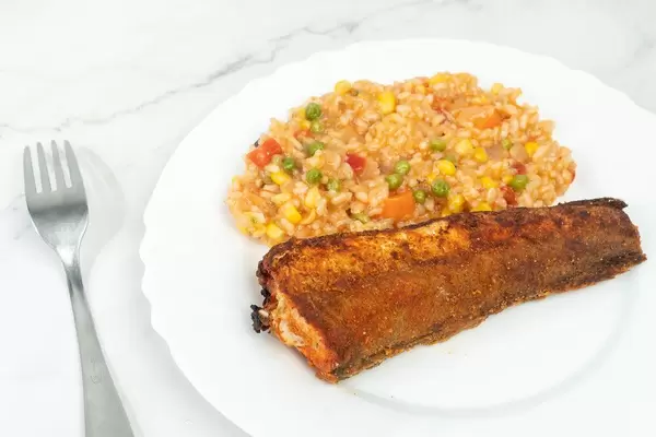 Hake served with Risotto and Vegetables on the white plate