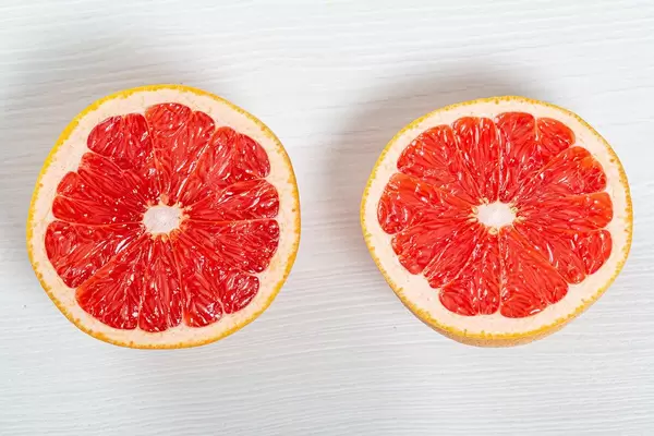 Halb in Scheiben geschnittene Grapefruit auf Holztisch in obene Aufnahme