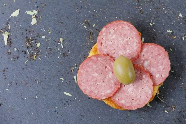 Halbes Brötchen mit Salami und Olive