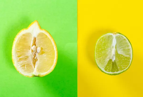 Halbierte Zitrone und halbierte Limone, mit farblich passendem Hintergrund