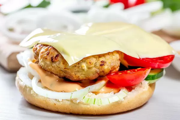 Half a hamburger bun with a filling close-up