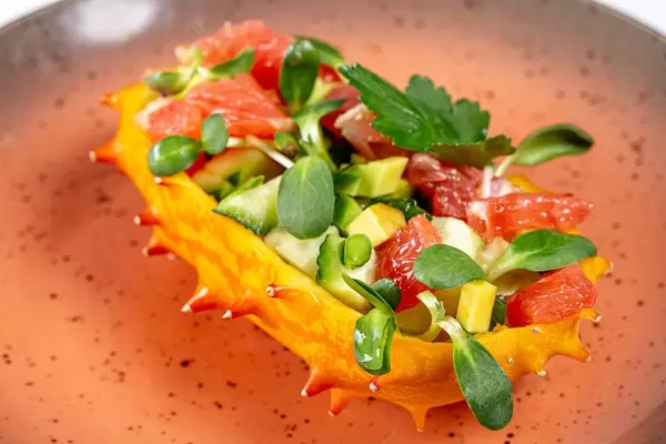 Half a Kiwano stuffed with fresh vegetables, slices of grapefruit and microgreens (Flip 2020)