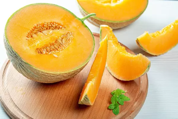 Half a melon and pieces on the kitchen Board