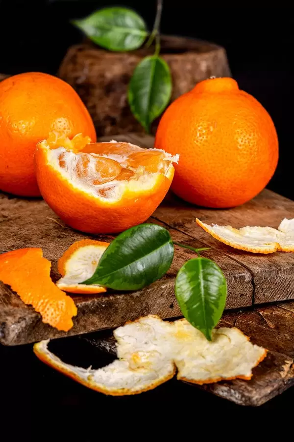 Half and whole fresh tangerines on old kitchen boards