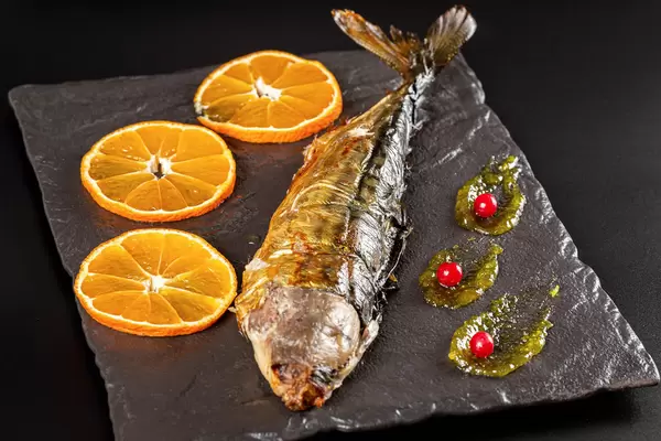 Half-baked mackerel with orange slices, close-up