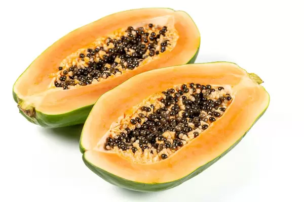 Half cut ripe papaya with seed on white background