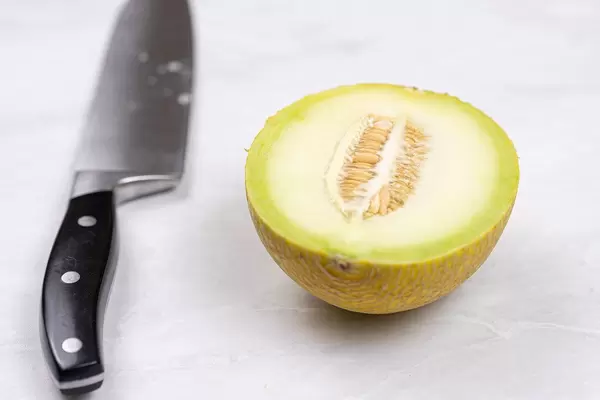 Half Mini Melon on the grey table with knife