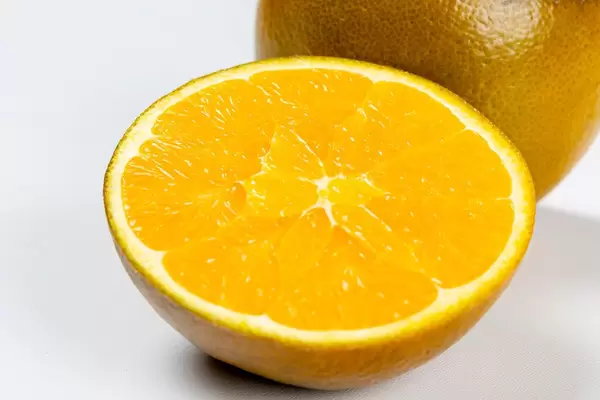 Half of a ripe orange with a brown rind