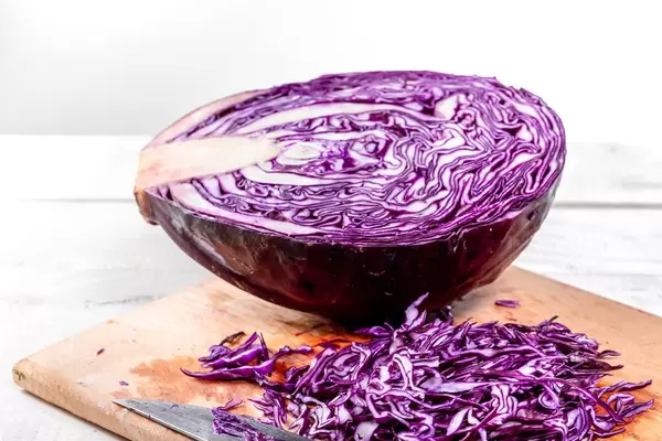 Hälfte Rotkohl mit geschnittenen Stücken auf dem Tisch
