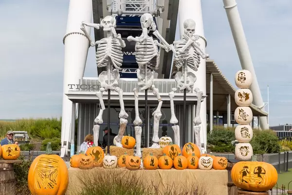 Halloween-Dekoration mit geschnitzten Kürbissen und Skelette im Affen-Emoji Style