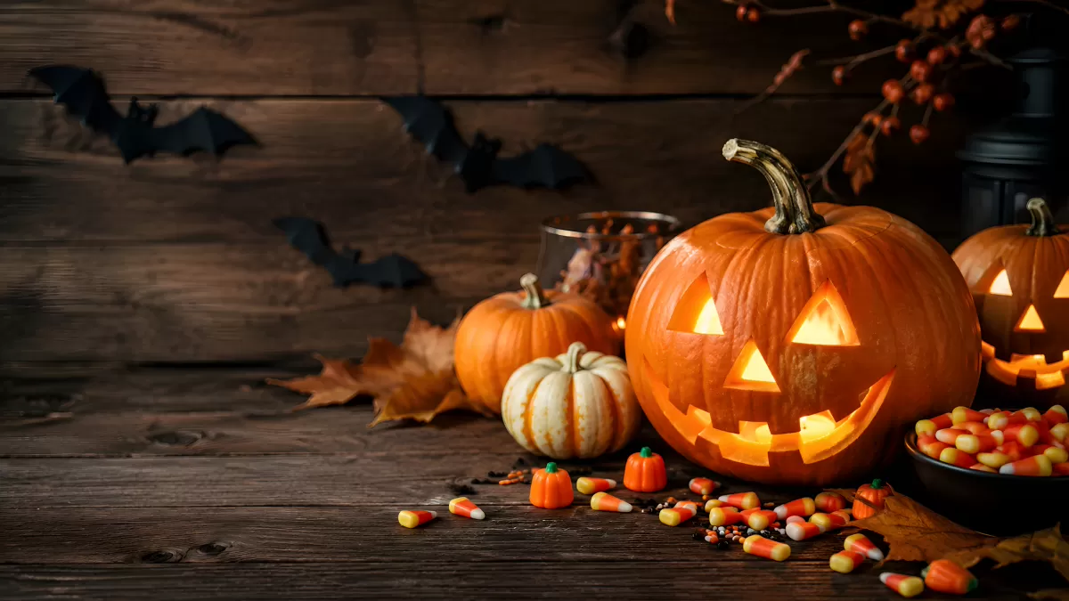 Halloween-Dekoration mit leuchtenden Kürbissen und Süßigkeiten