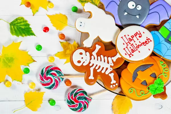 Halloween gingerbread and candies with yellow leaves
