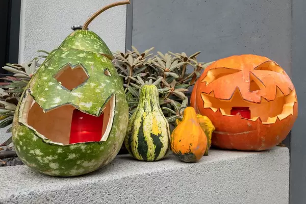 Halloween Kürbisse mit Grimassen vor einem Haus