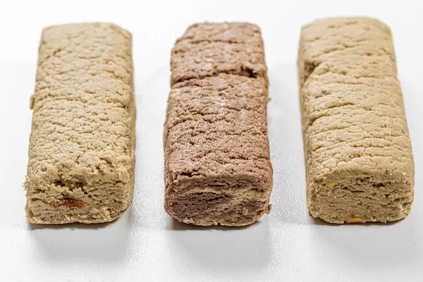Halva Nachttisch mit Erdnüssen, Rosinen und Kakao auf weißem Hintergrund