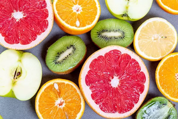 Halves of fresh fruit orange, grapefruit, lemon, kiwi and Apple. Top view