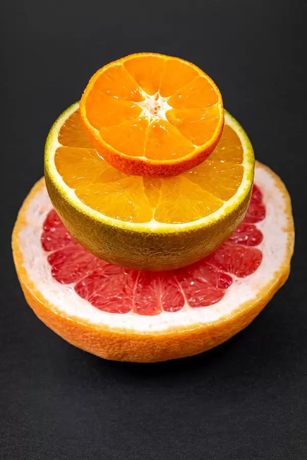 Halves of grapefruit, chocolate orange and mandarin on a black background (Flip 2020)