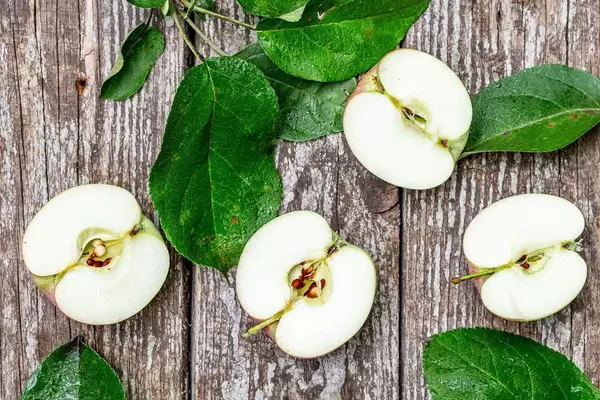 Halves of ripe apples on an old wooden background. Top view (Flip 2019)
