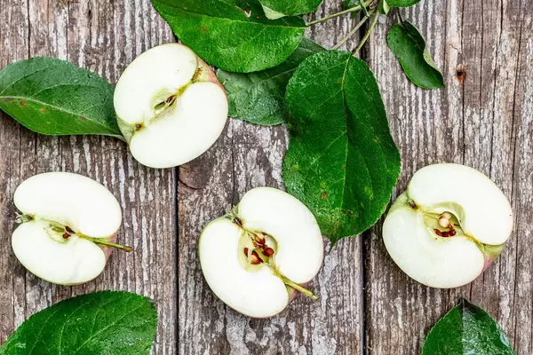 Halves of ripe apples on an old wooden background. Top view